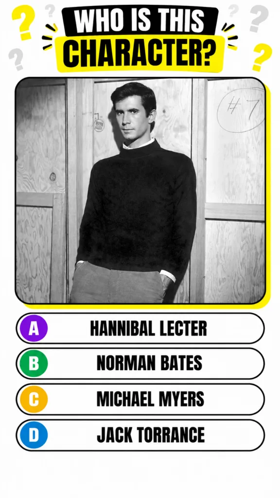 Anthony Perkins in a black and white photo leaning against a light-colored wooden background hands in pockets wearing a 