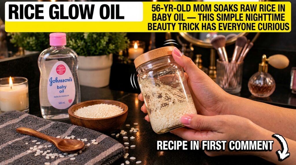 A hand holding a clear glass jar filled with raw rice and baby oil with a bottle of baby oil a bowl of dry rice and a li