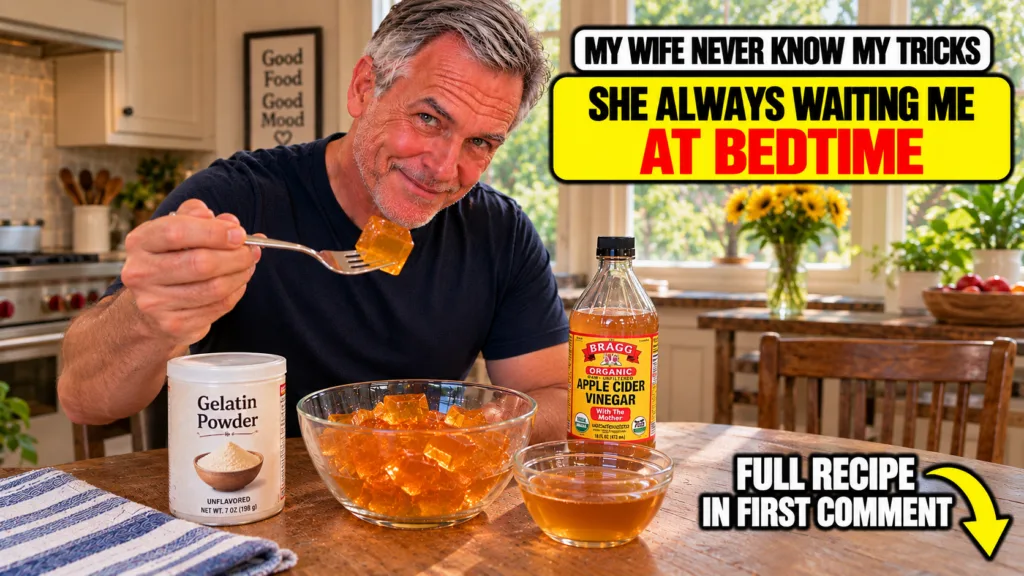 A smiling man holding a fork with a piece of gelatin with a bowl of orange gelatin cubes a bottle of apple cider vinegar