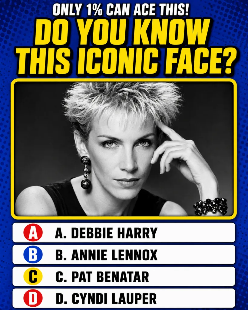 A black and white portrait of Annie Lennox with short spiky hair wearing a prominent dangling earring and a beaded brace