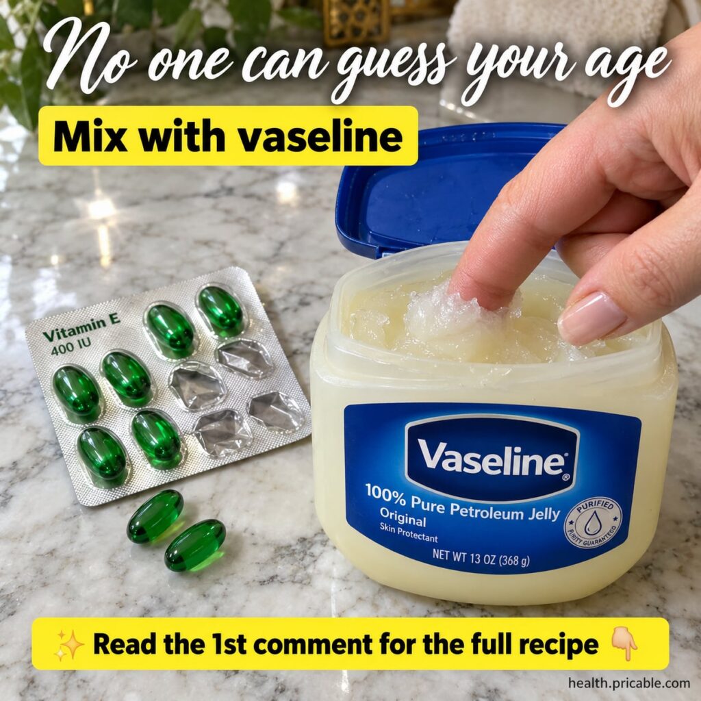 A close-up of a small elegant glass jar containing a creamy off-white balm with a Vaseline tub and a few amber Vitamin E