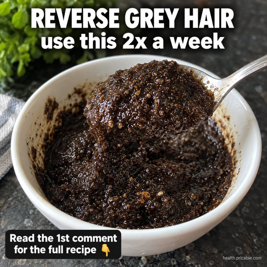 A close-up shot of a dark natural hair paste in a small bowl with a wooden spoon beside it ready for application