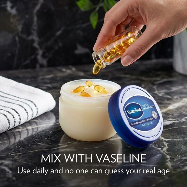 A close-up shot of an open Vaseline jar next to a few golden nourishing capsules possibly Vitamin E or similar with a sm