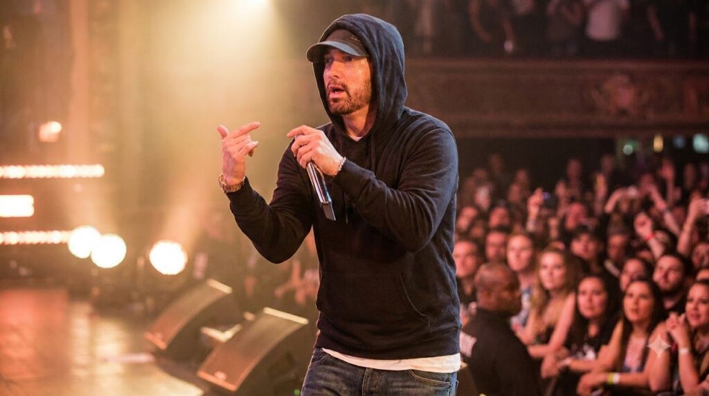 Eminem performing on stage with a microphone showcasing his energetic stage presence He is in his prime wearing casual h