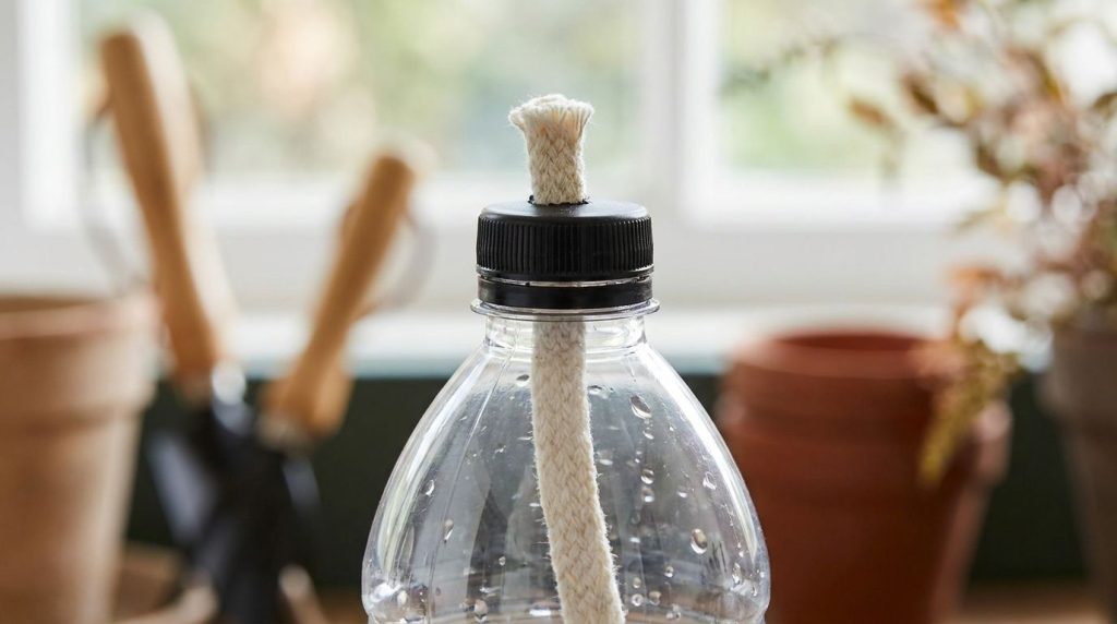 Close-up of a plastic bottle top section with a cotton wick threaded through the bottle cap ready for assembly