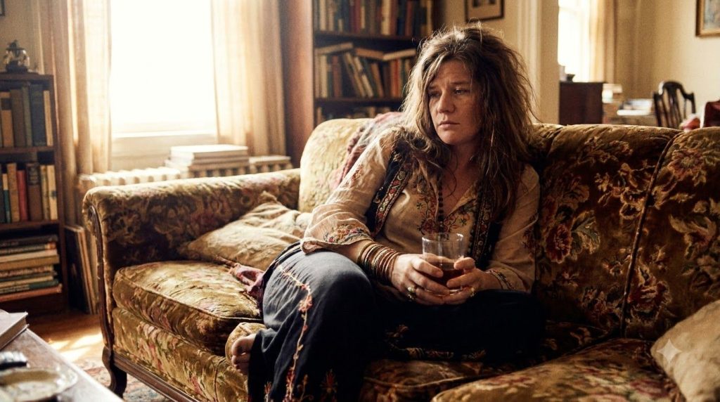 The album cover for Janis Joplin s Pearl showing her in a relaxed pose with a drink captured in a classic album art styl