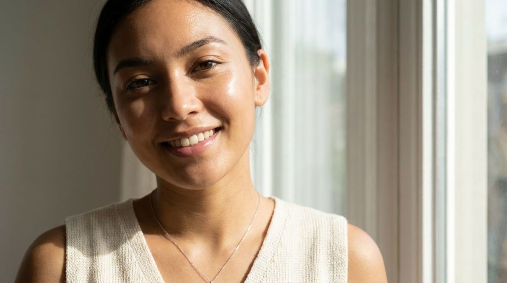 A woman with radiant clear glass skin smiling confidently