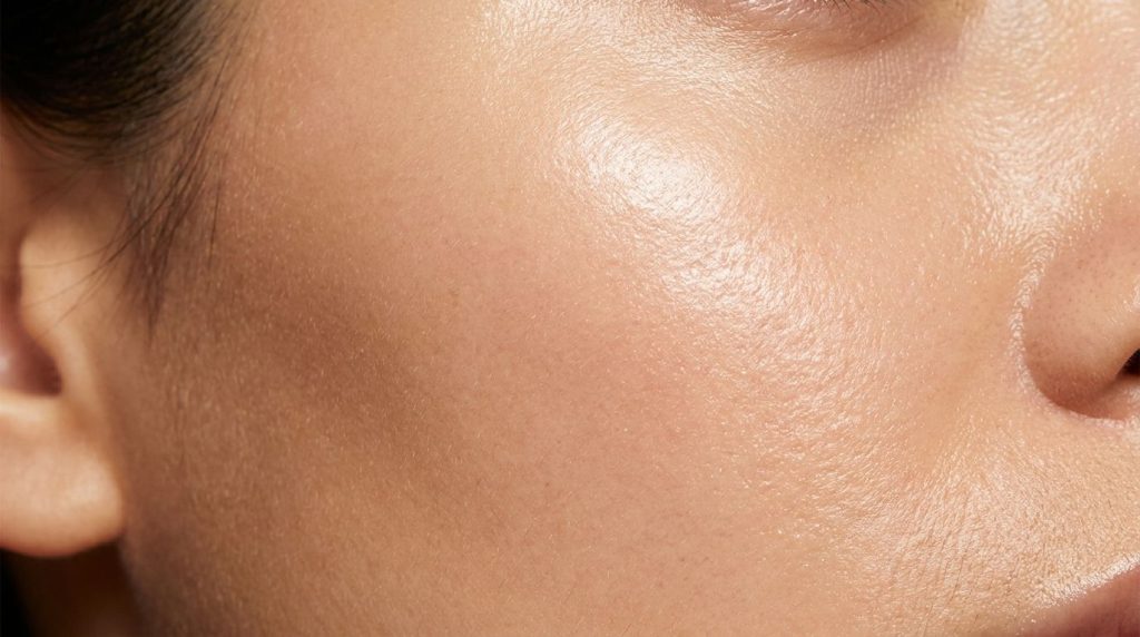 A close-up of smooth hydrated skin showing a subtle glow representing the results of using baby oil