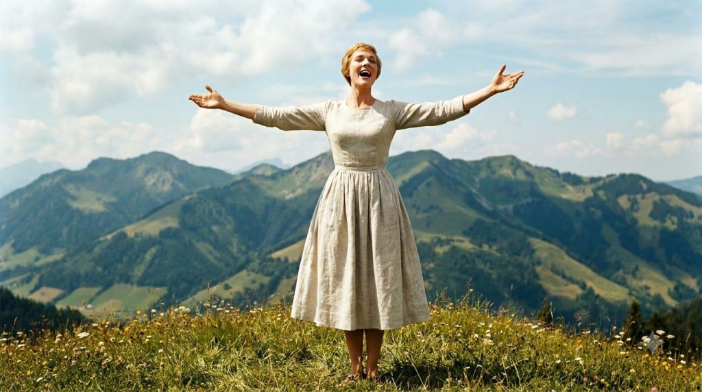 Julie Andrews famously singing The Hills Are Alive on a mountain top from The Sound of Music arms outstretched