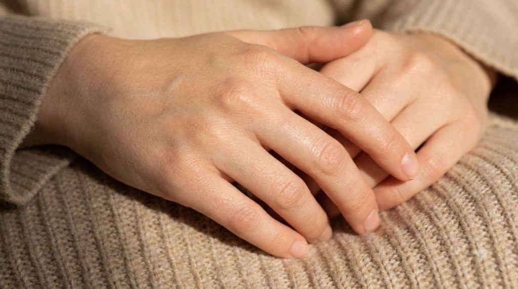 A person s hands looking soft and smooth after a hand mask possibly holding a small flower or gently clasped to emphasiz