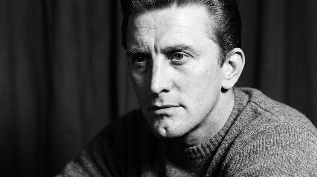 A real black-and-white publicity photo of a young Kirk Douglas showing his distinctive cleft chin and intense gaze