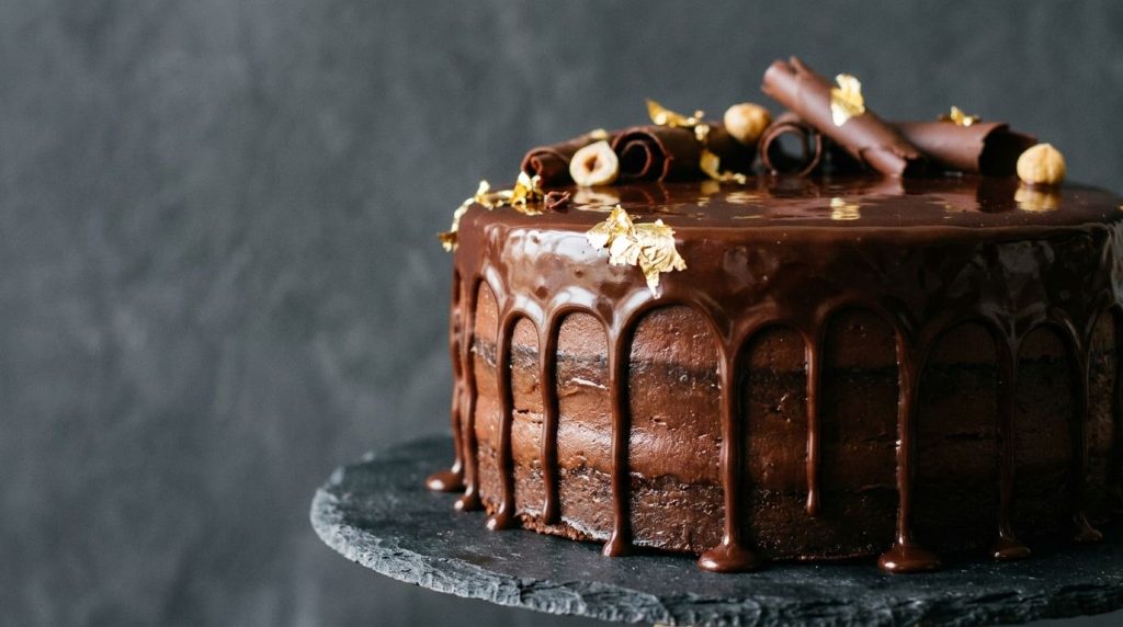 A shiny smooth chocolate ganache dripping elegantly over the side of a cake with a rich dark appearance