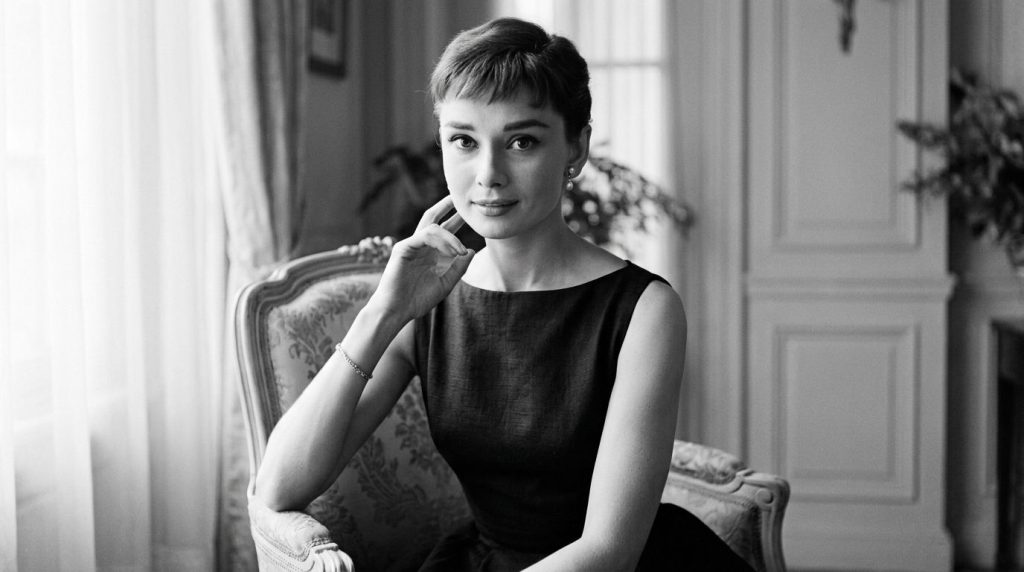 A classic black and white publicity photo of Audrey Hepburn showcasing her iconic elegance and fashion style from the 19