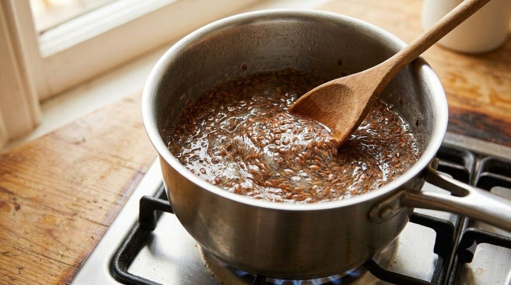 A close-up shot of flaxseeds simmering in water in a saucepan showing the mixture thickening into a gel