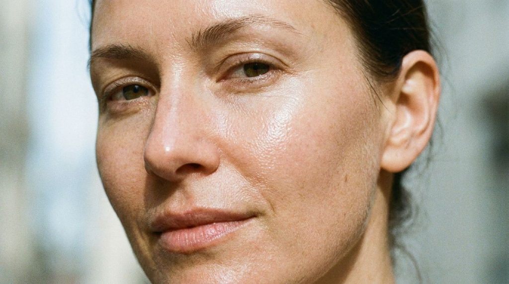 A close-up of a woman s face after applying the glow gel showing healthy luminous skin with a subtle glow