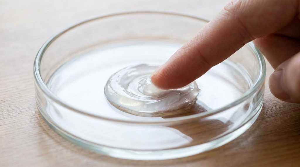 Close-up of Vaseline and baby oil being mixed in a small dish to create a smooth translucent balm