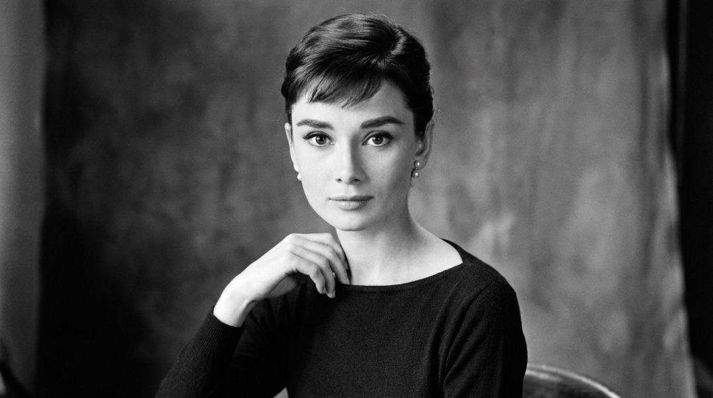 A real archival publicity photo of Audrey Hepburn in a classic pose showcasing her elegant style She might be wearing a 