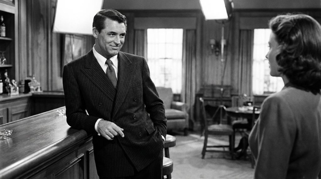Cary Grant in a classic suit exuding his signature suave and charming demeanor from a film scene