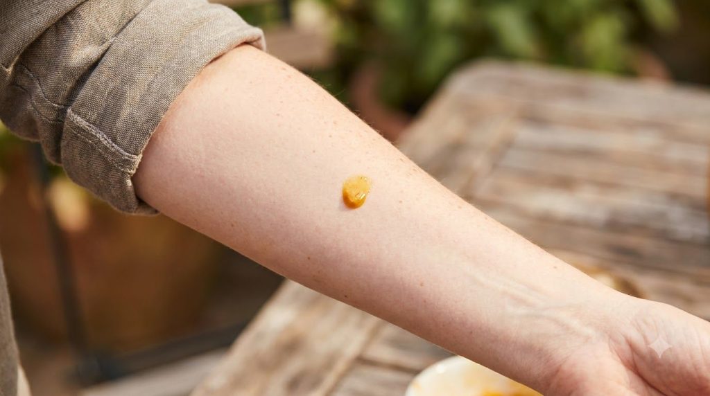 Una mujer haciendo una prueba de parche en su antebrazo con una pequeña cantidad de la mezcla de aceite de bebé y cúrcum