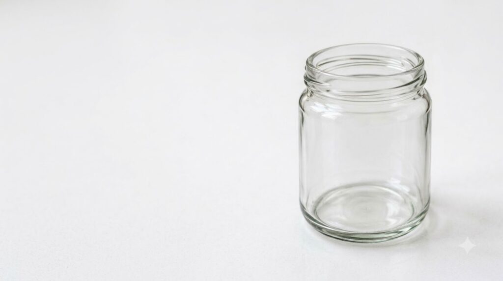 A clear glass jar filled with layers white coarse salt at the bottom a light blue liquid on top of the salt and several 