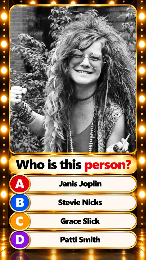 Black and white portrait of a young Janis Joplin with wild curly hair round glasses a wide smile wearing bangles and hol