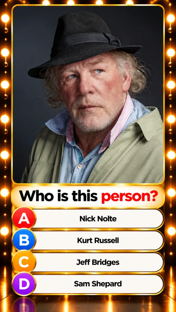 A striking portrait of actor Nick Nolte an older man with blue eyes wispy grey hair and beard wearing a dark fedora a li