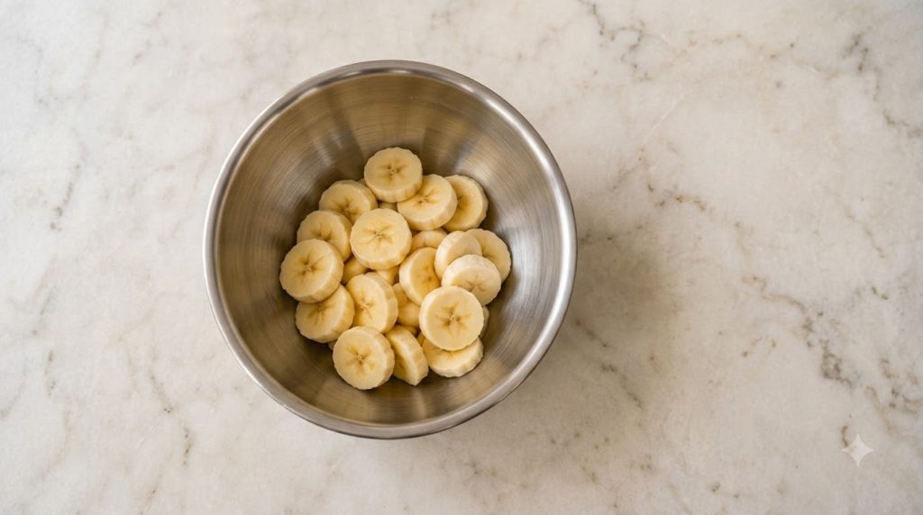 A stack of fluffy golden-brown flourless banana pancakes garnished with fresh banana slices and a light drizzle of maple