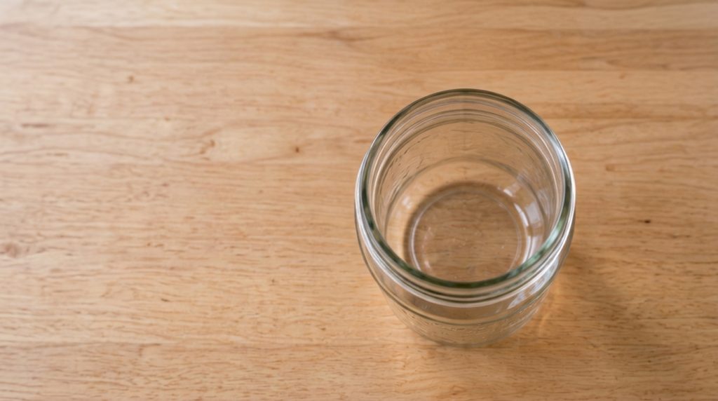 A bowl of fresh homemade sour cream with a spoon resting in it showing its creamy texture