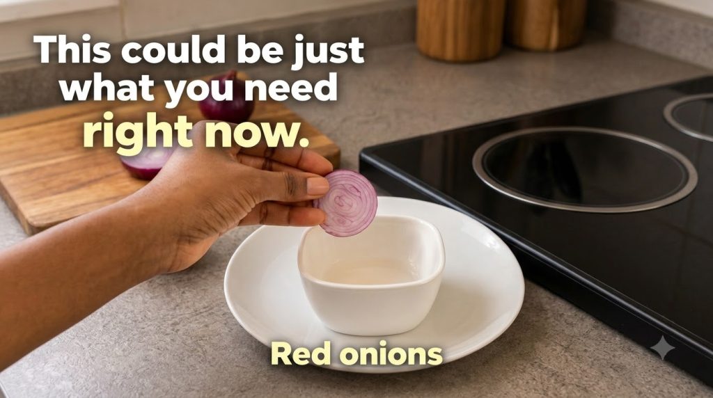 A hand holding a thinly sliced red onion over a small white bowl with clear liquid ready to be prepared as a toner
